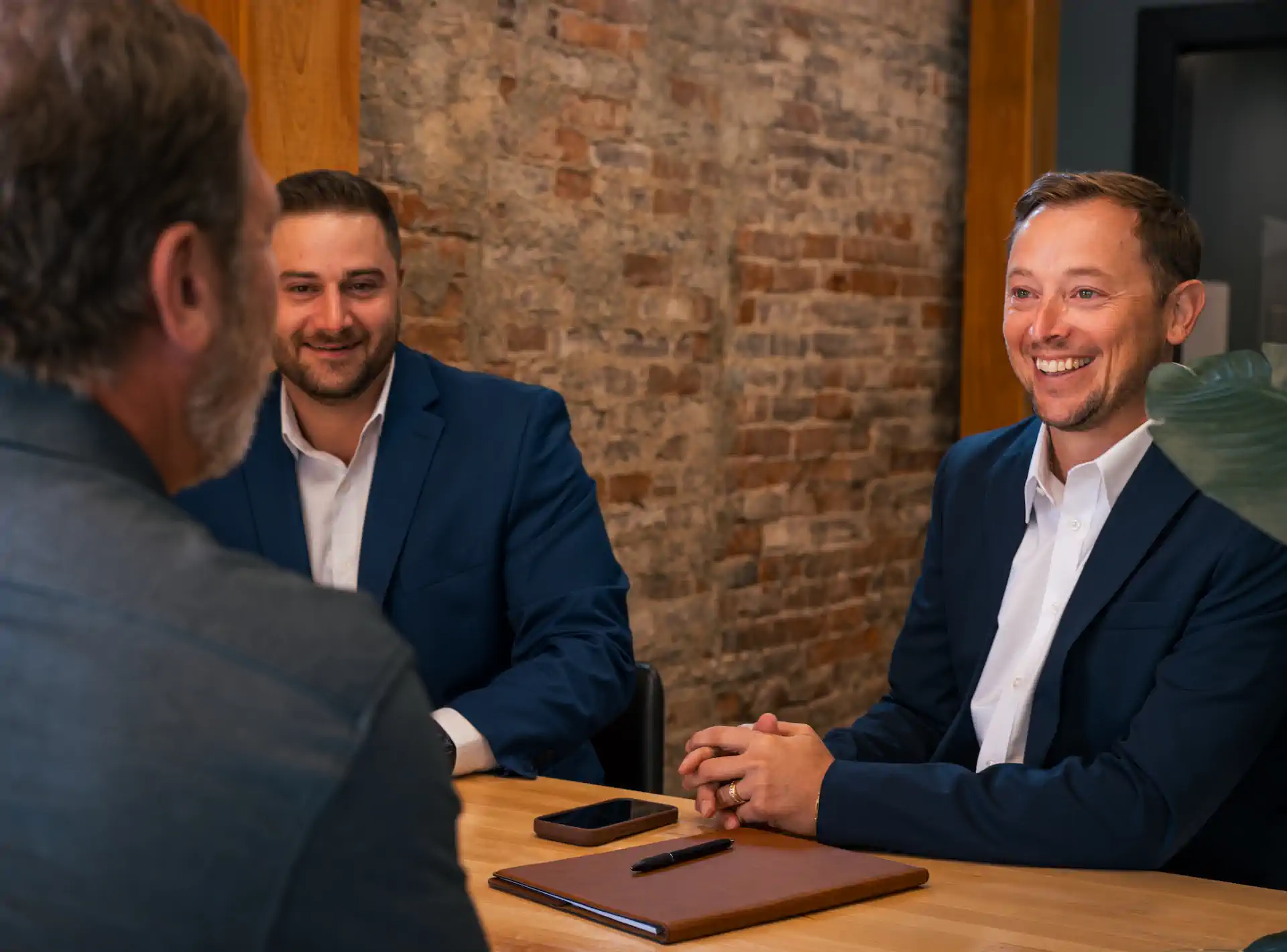 Jacob Hogg and Jordan Marler of Trinity Management sitting down with a business owner