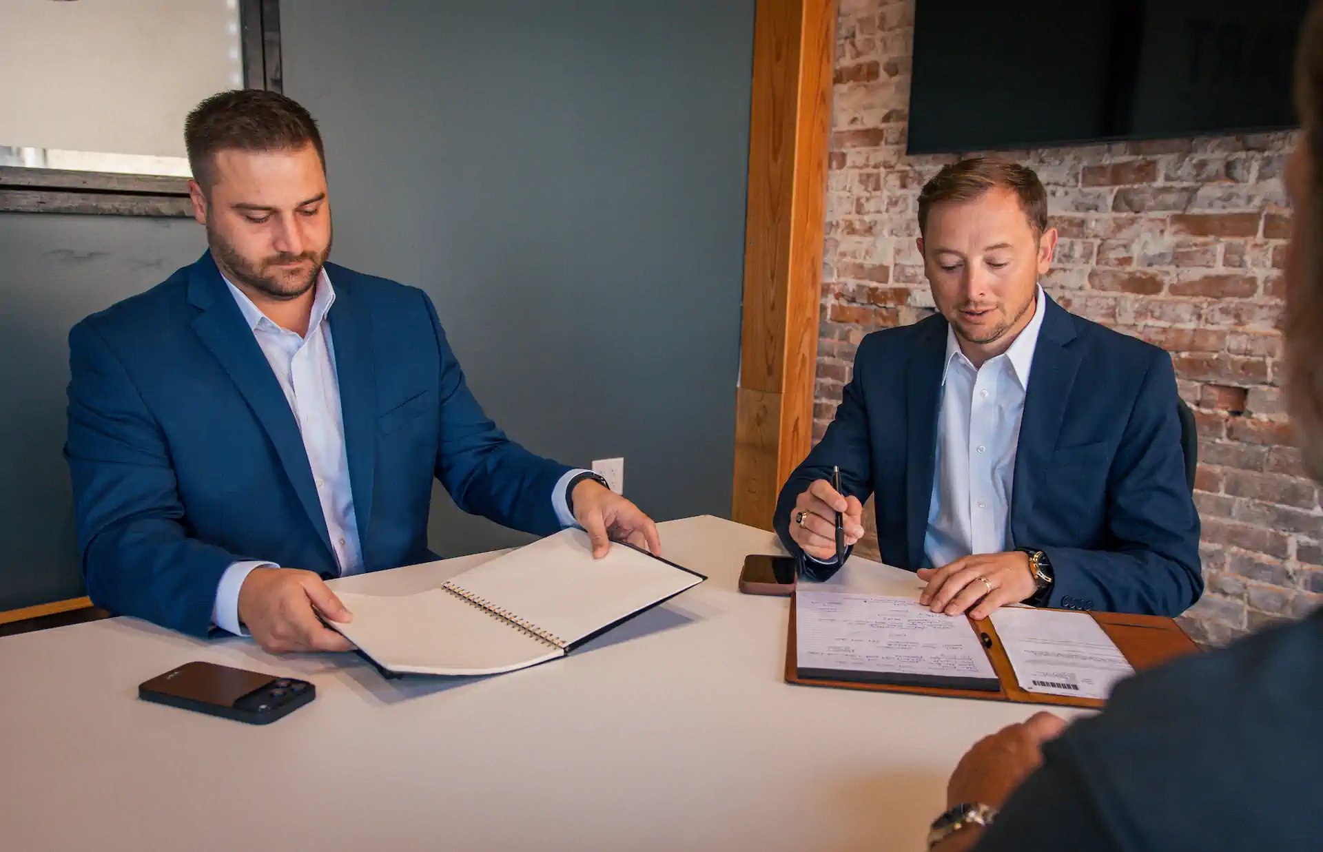 Jordan Marler and Jacob Hogg working through an owner's numbers across the table